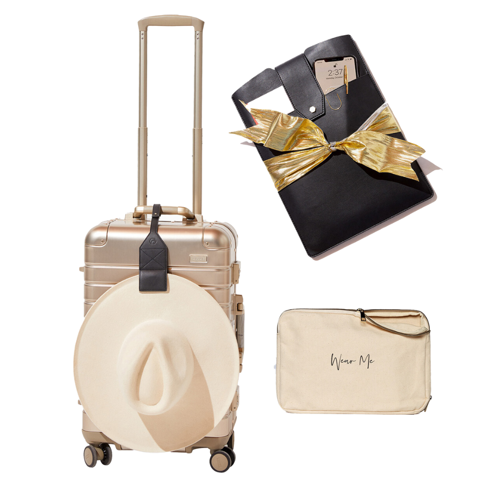 Elegant stocking stuffers: stylish hat on gold luggage, black notebook with golden bow, and a beige travel pouch.