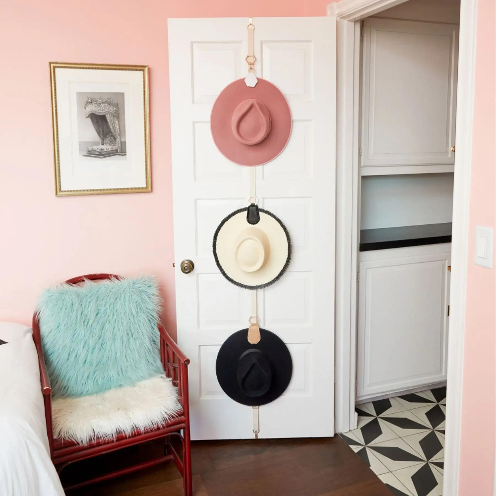 Over-the-door hat organizer with three hats in an organized, stylish bedroom closet setup.