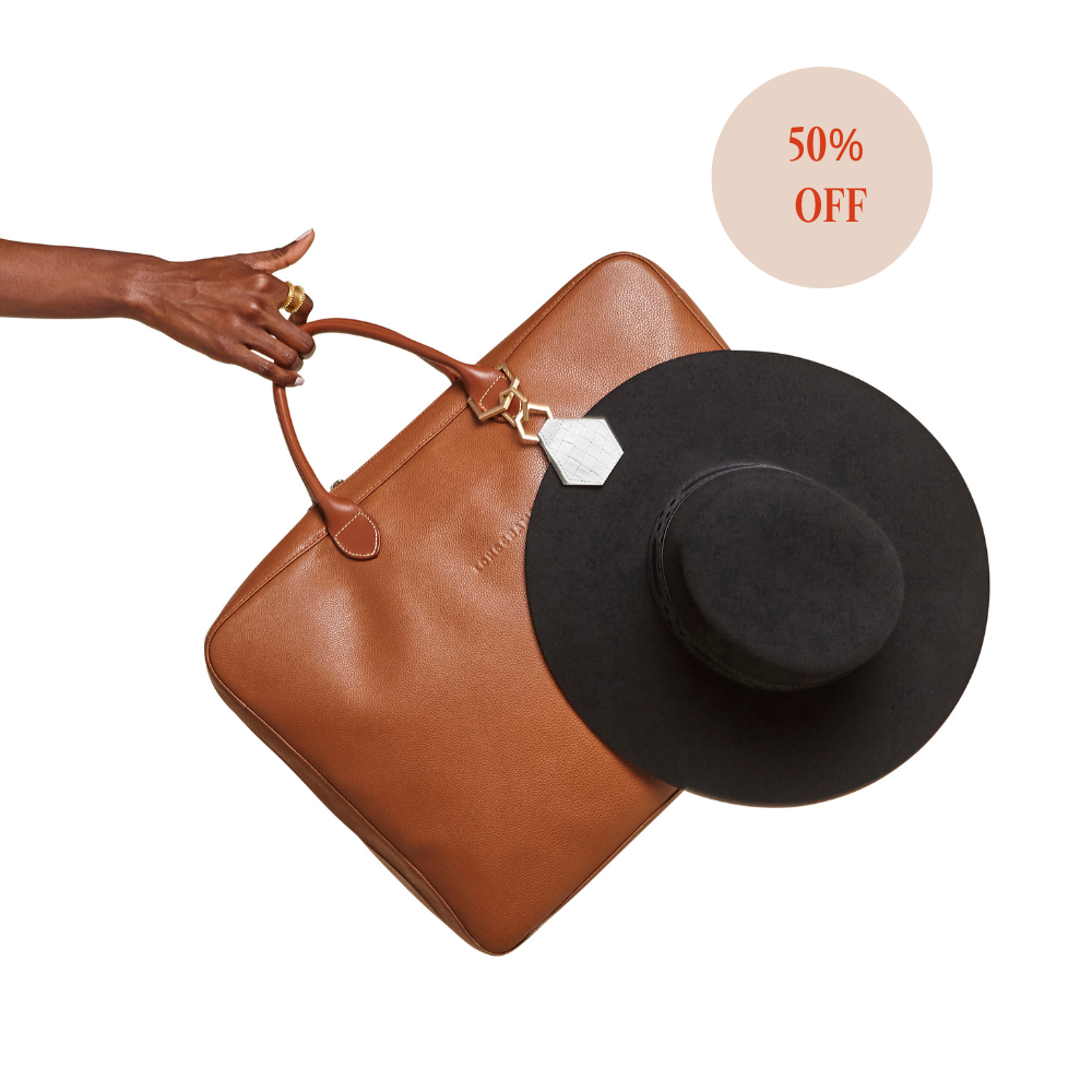Hex TOPTOTE hat clip holding black hat on brown bag with 50% off label
