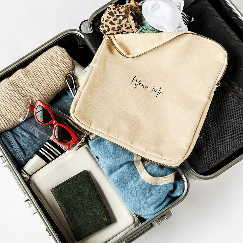 Two-sided travel laundry bag in a packed suitcase with clothes, red sunglasses, and a passport, ideal for separating clean and dirty laundry.