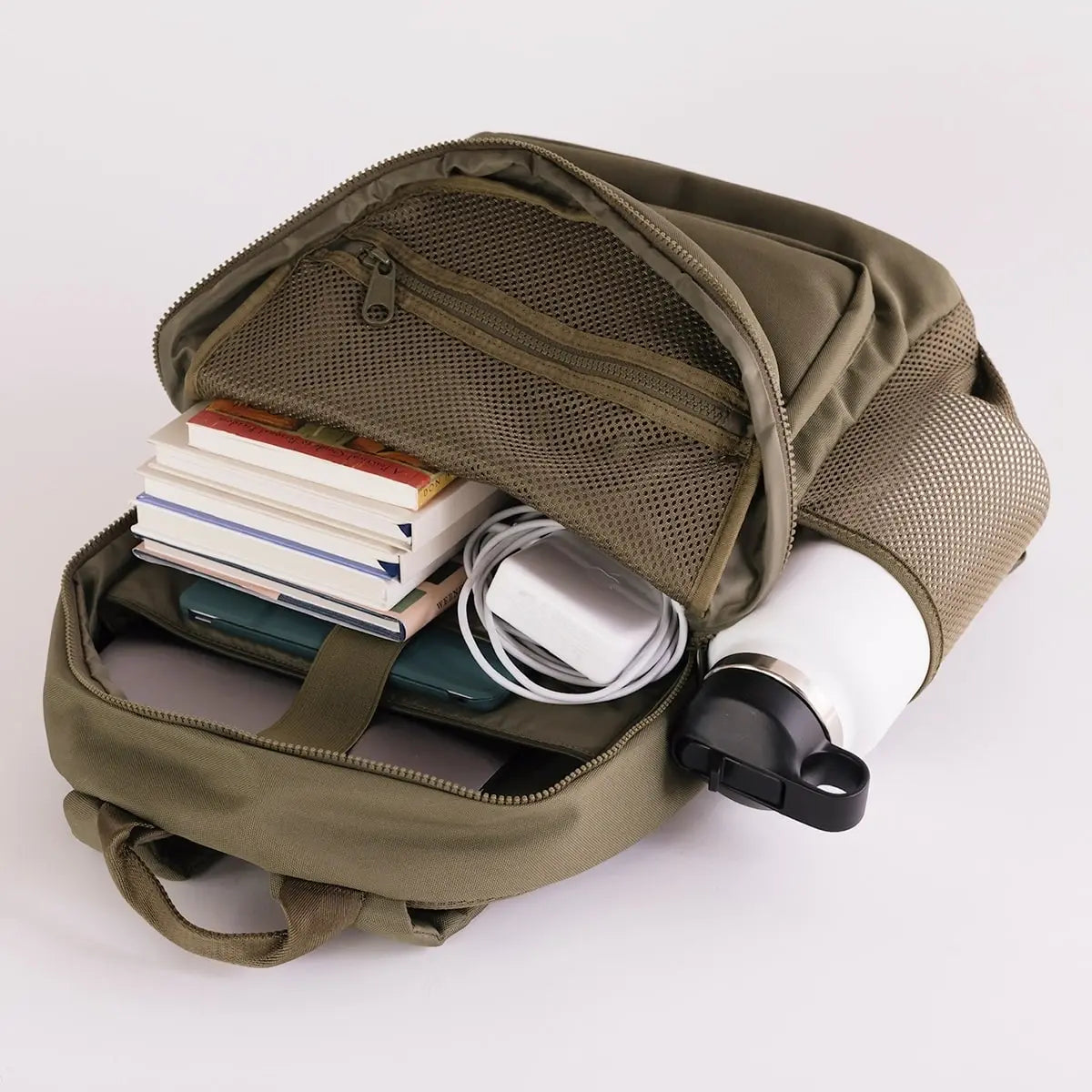 August Noa travel backpack in olive. Front view with main pocket open to show storage.