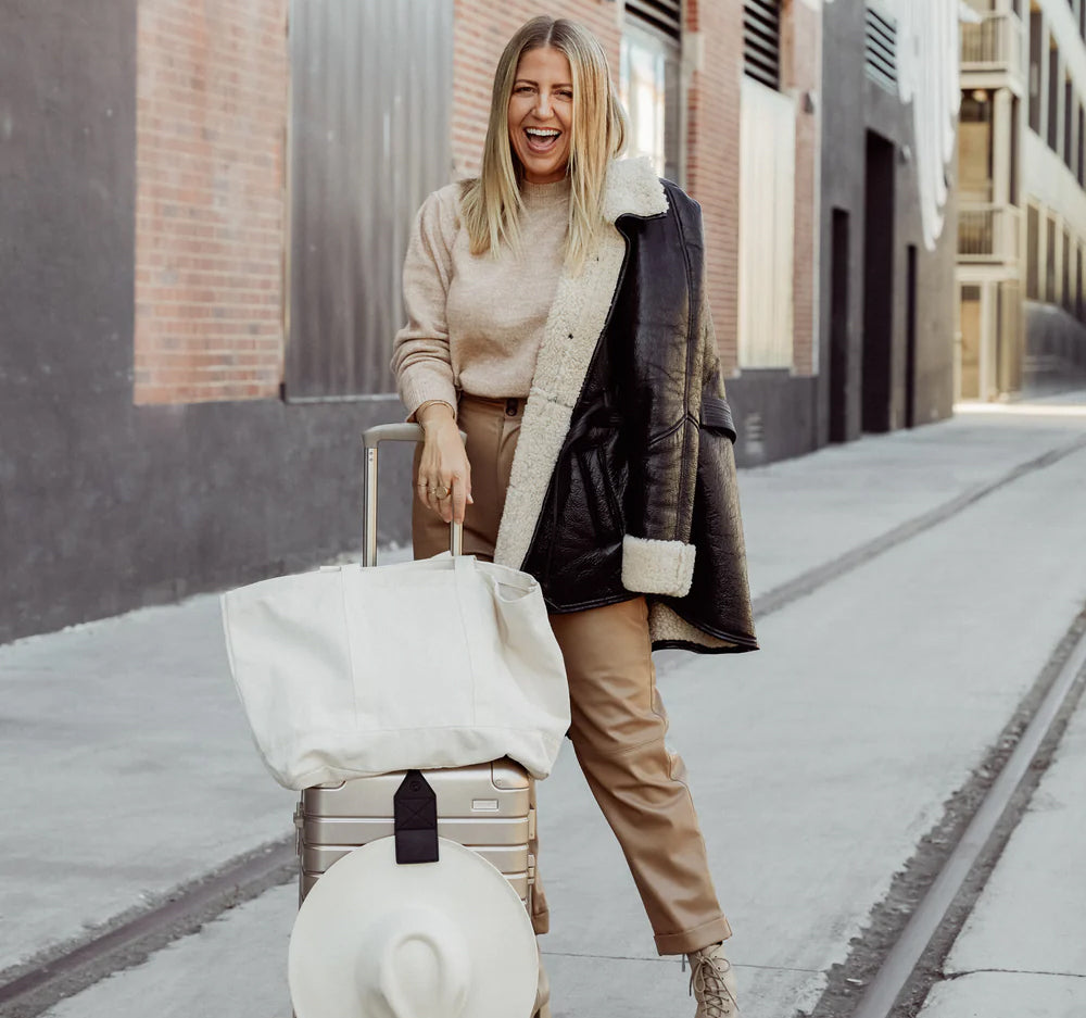 Lindsay Albanese traveling in style using the TOPTOTE Luggage Hat Holder Clip