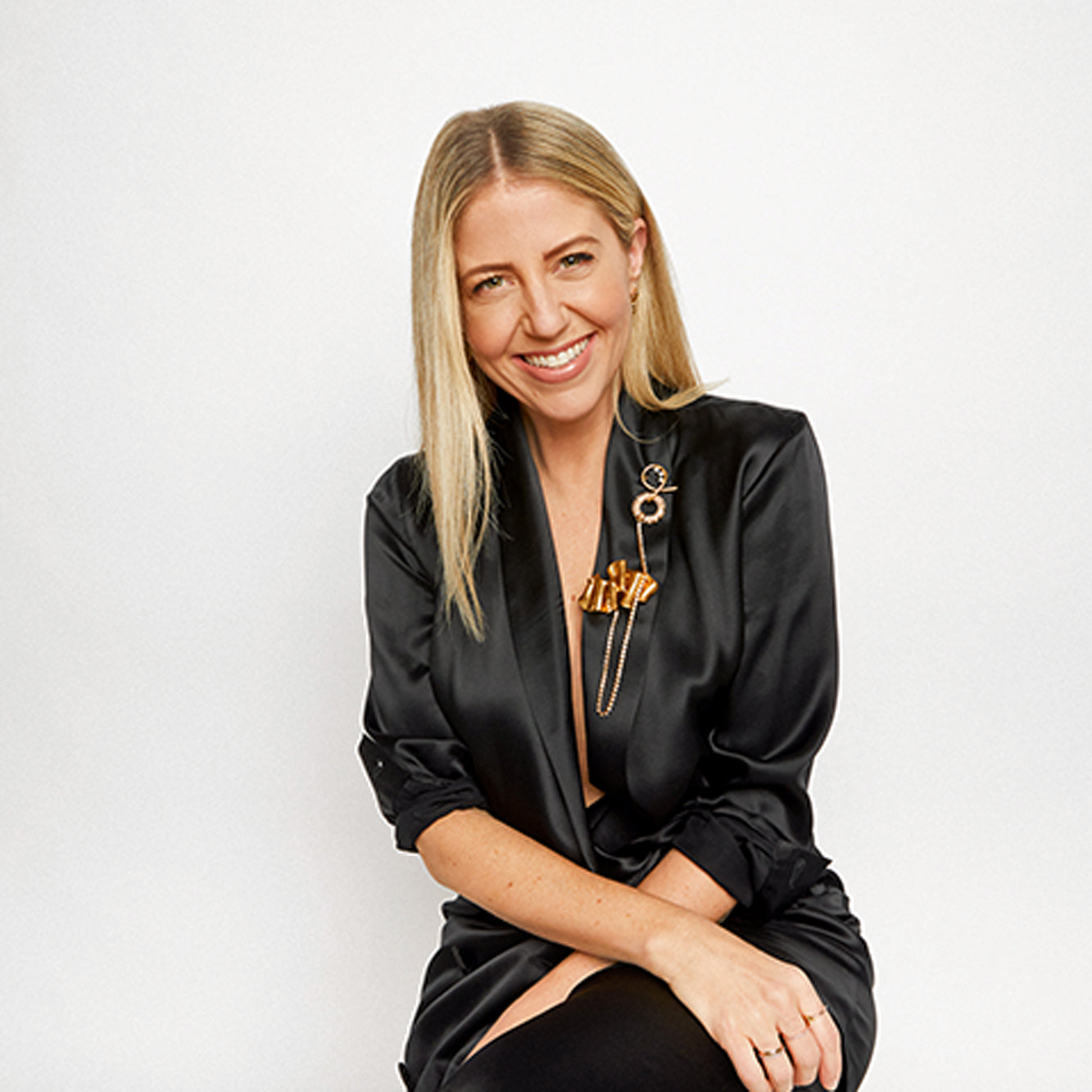 Lindsay Albanese inventor of the TOPTOTE wearing all black sitting down.
