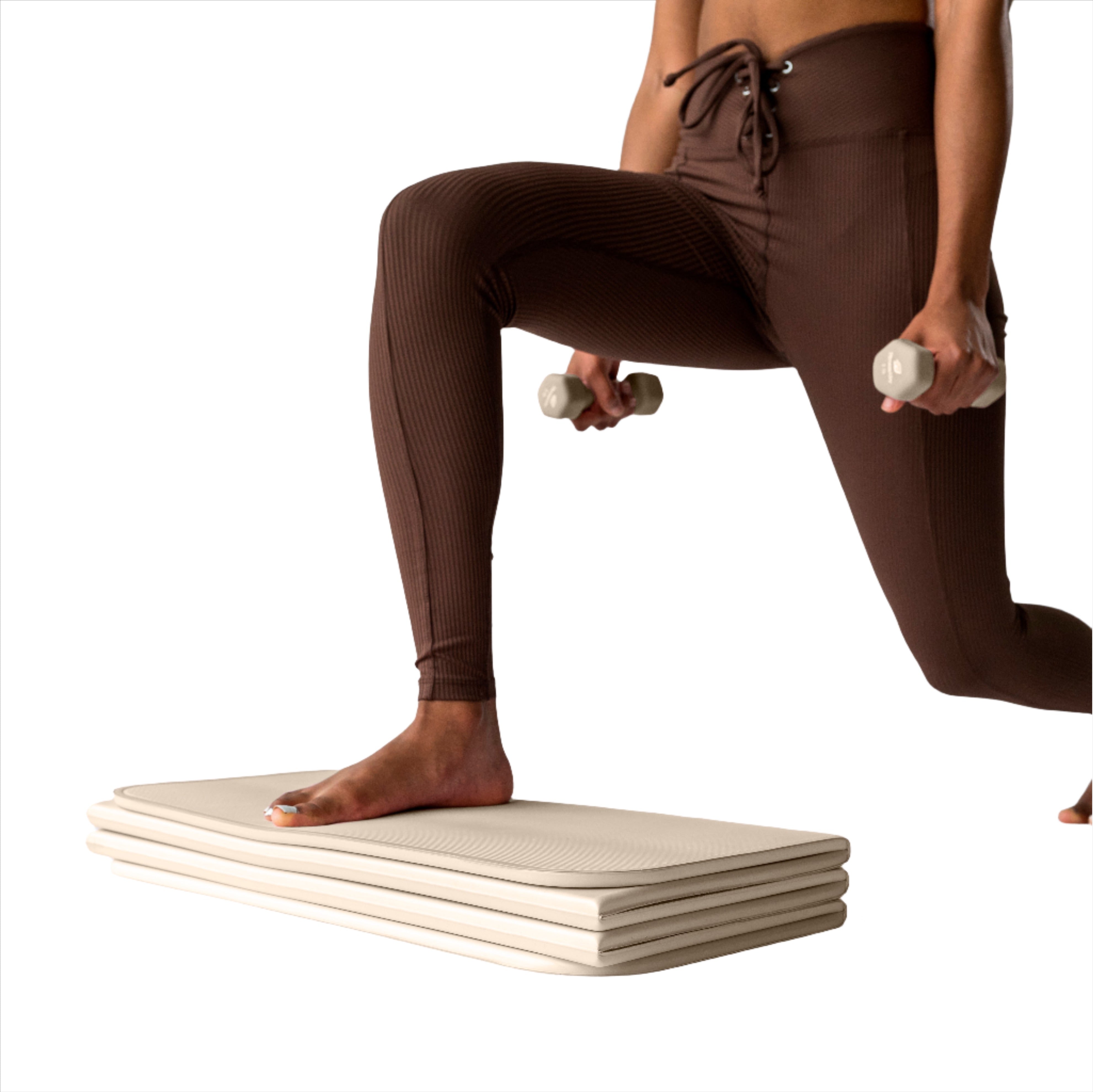 Woman working out on STAKT foldable yoga mat as a block for leg squats