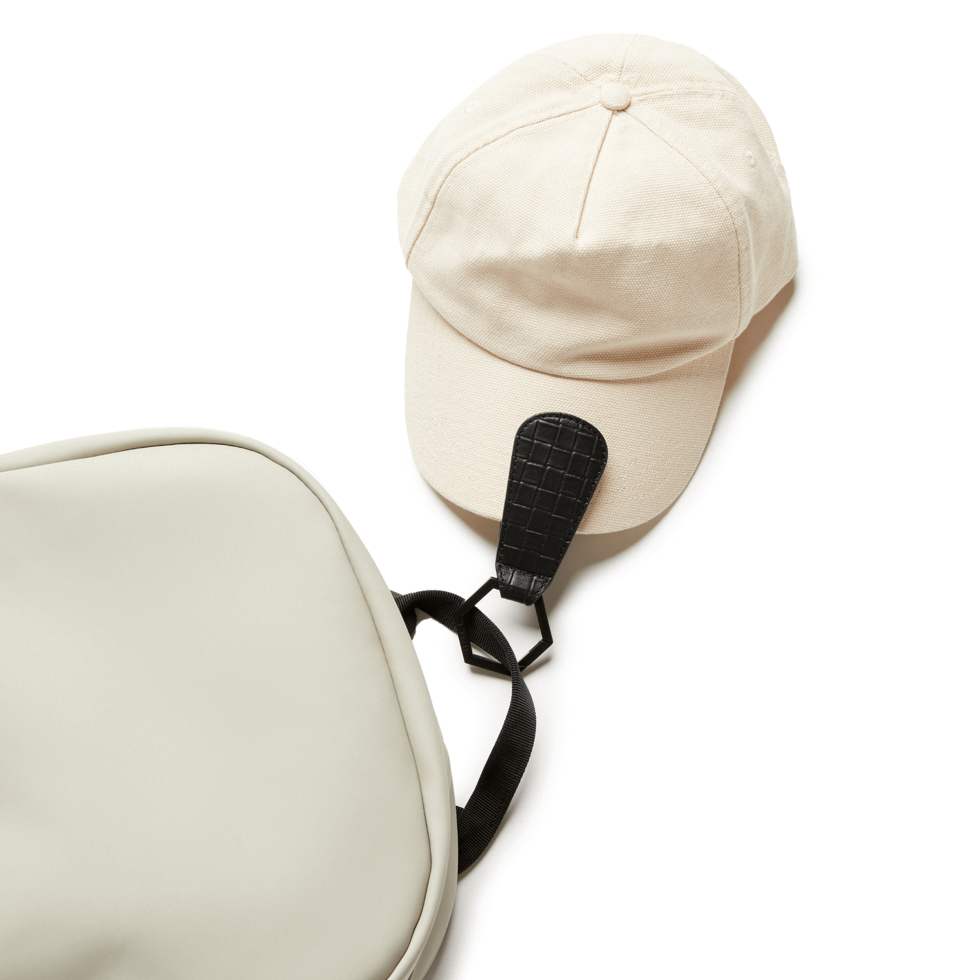 TOPTOTE The Drop Hat Holder Clip attached to ballcap and a backpack