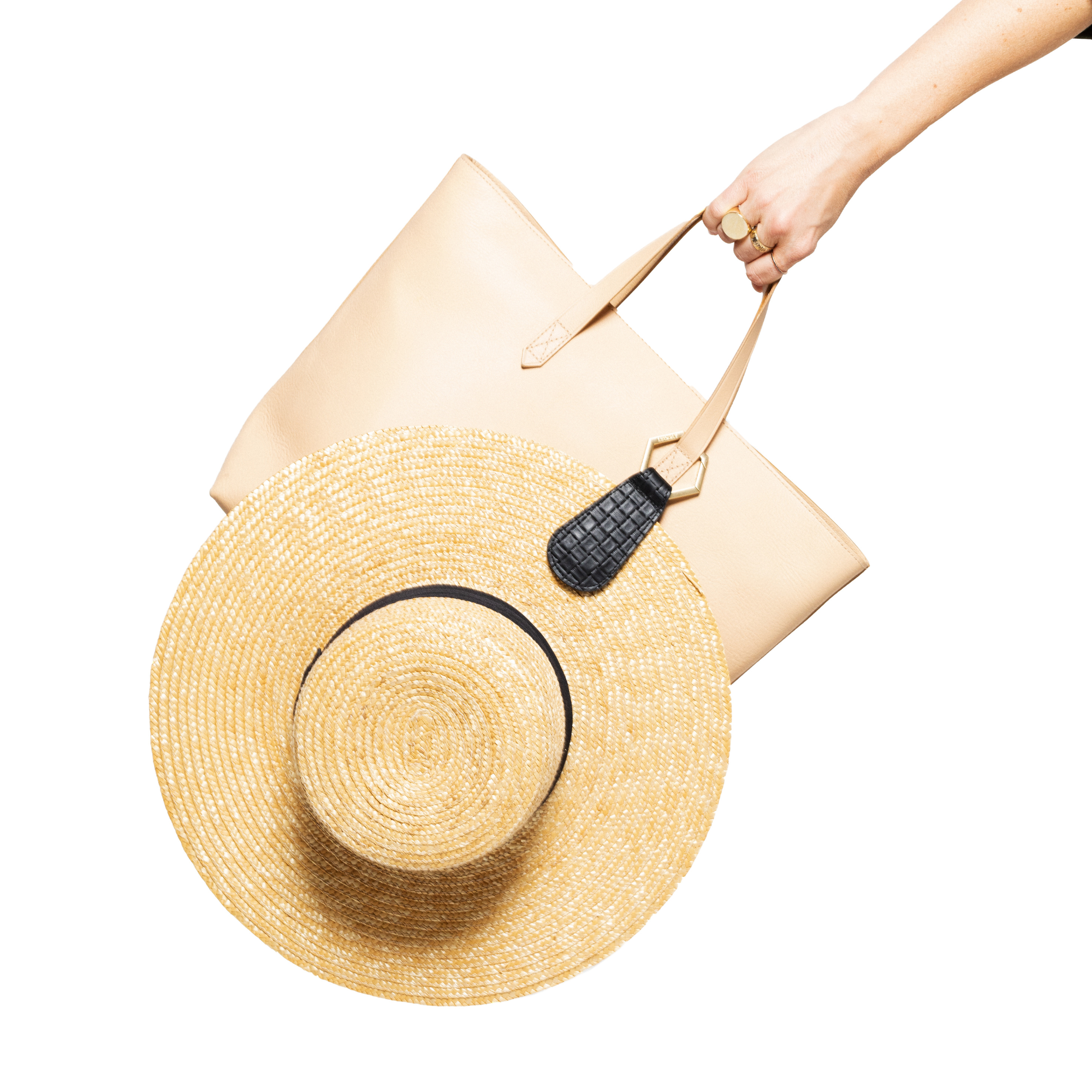 Hat attached to brown leather handbag with The Drop TOPTOTE hat clip showing hands-free travel convenience