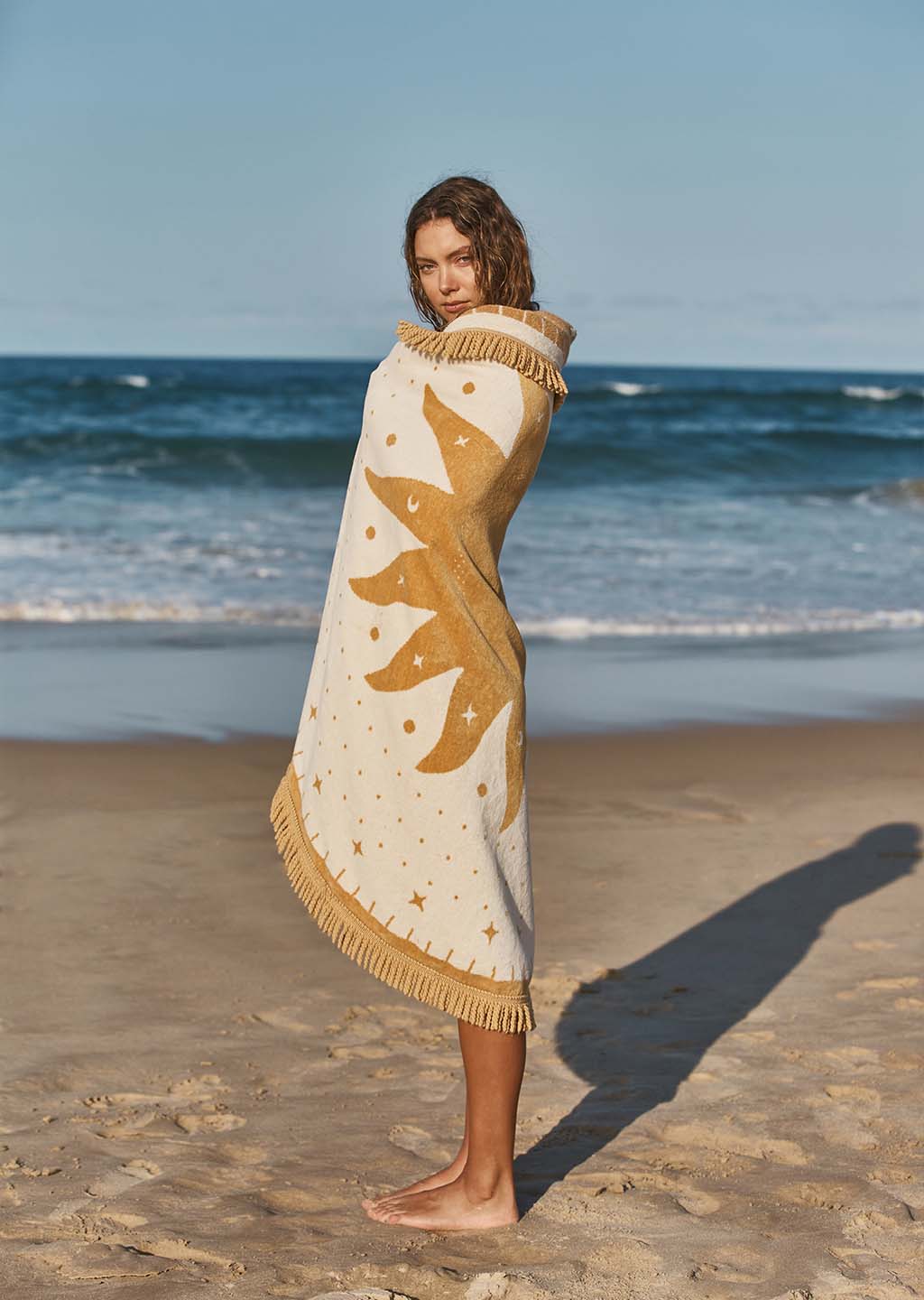 The Beach People Lune Round Beach Towel wrapped around a woman on the beach